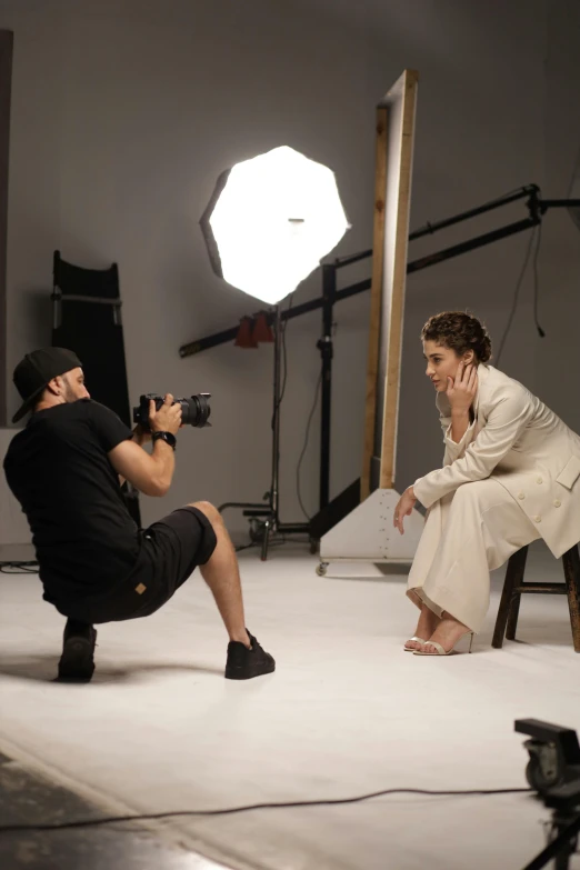 a man taking a picture of a woman, while she holds the camera