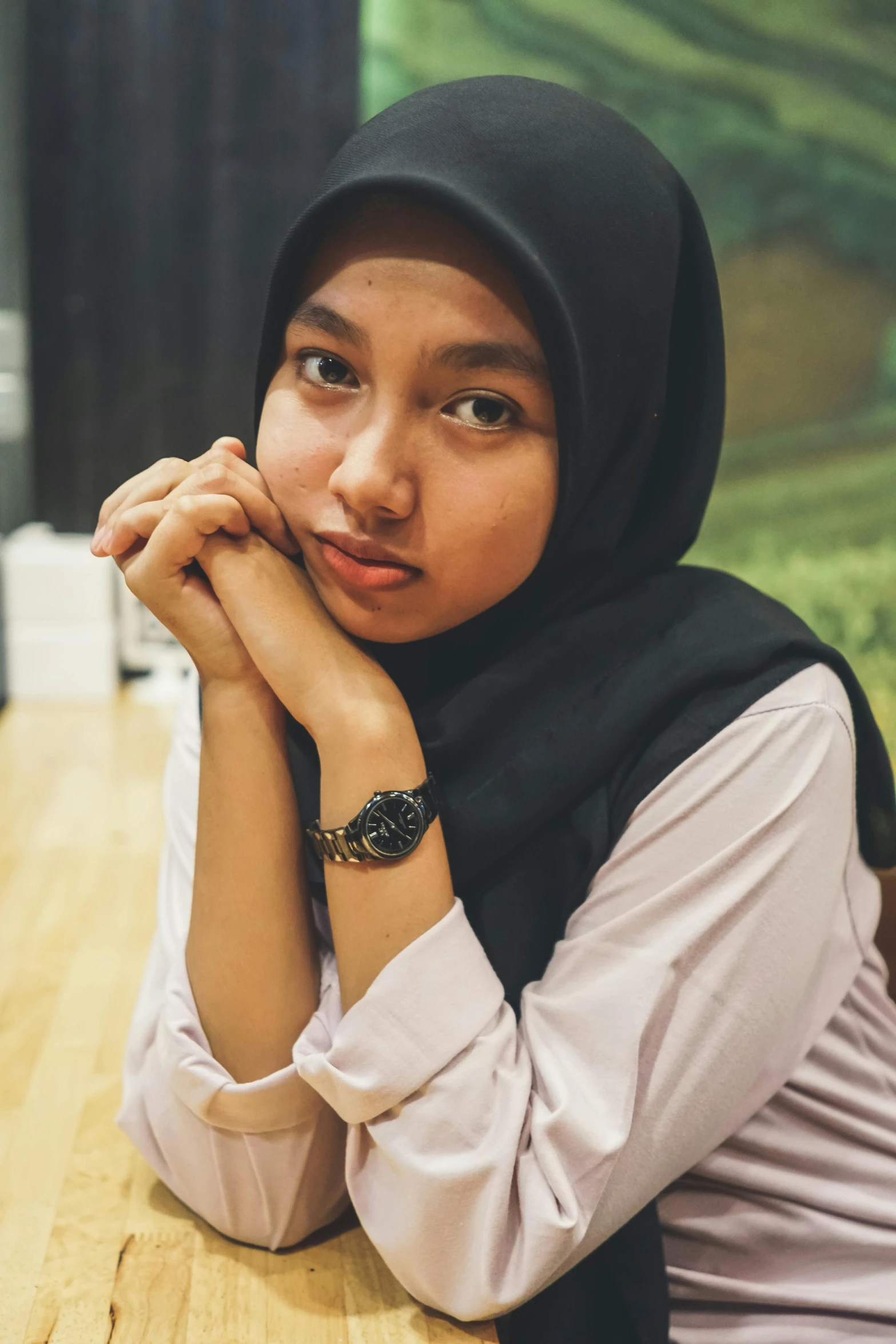 a woman in a scarf poses on a table