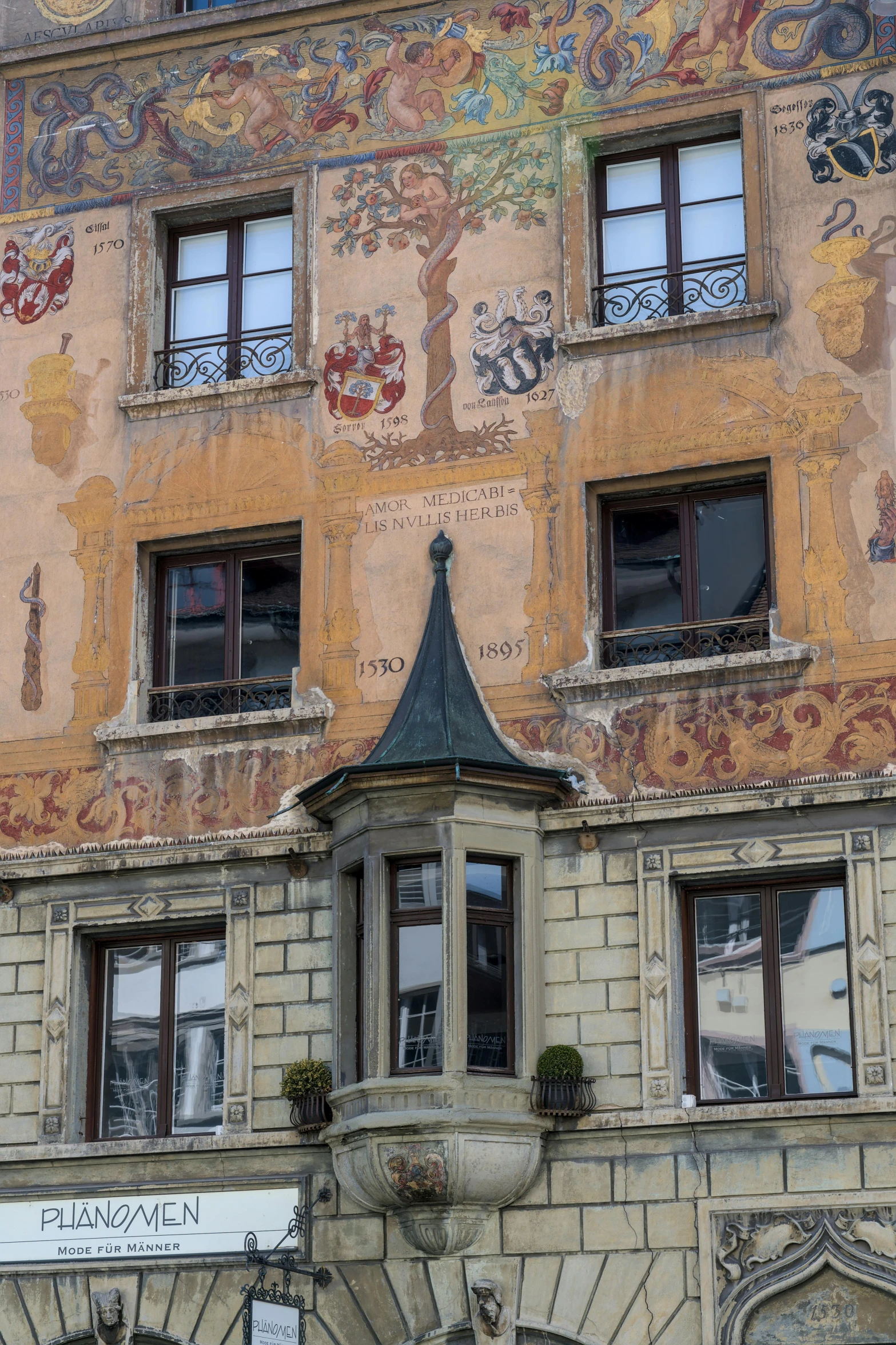 an old building with many windows and an artistic painting on the wall