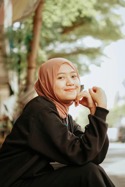 young woman in burka sitting and talking on cell phone