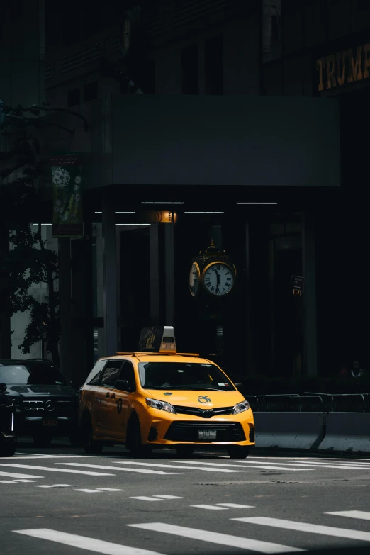 a taxi cab waiting at a bus stop with its lights on