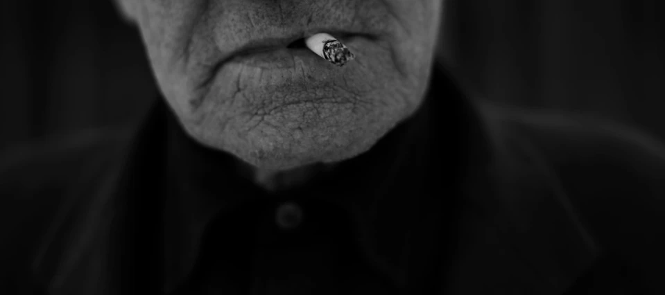 an old man with a nose ring has soing on his nose