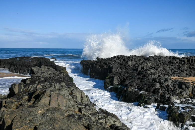 waves crashing against the rock on a beach