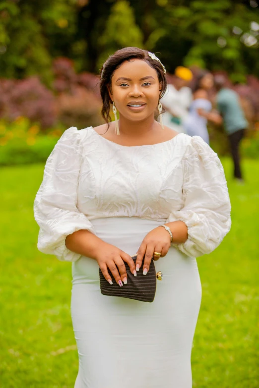 a woman in white dress with a small purse