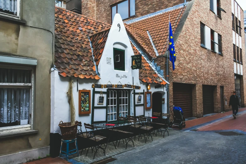 an old style building with flags on a street corner