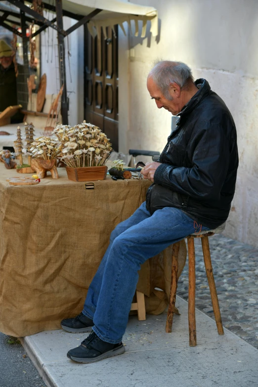 a man that is sitting in a chair looking at his phone