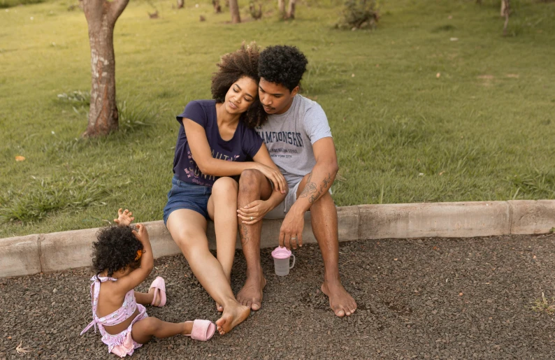 a young family sitting together at the park