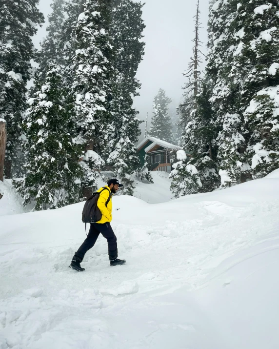 a man wearing yellow walking in the snow