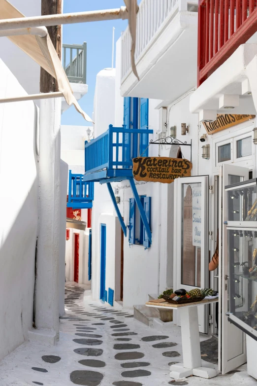 a narrow street in the white village with blue and red doors