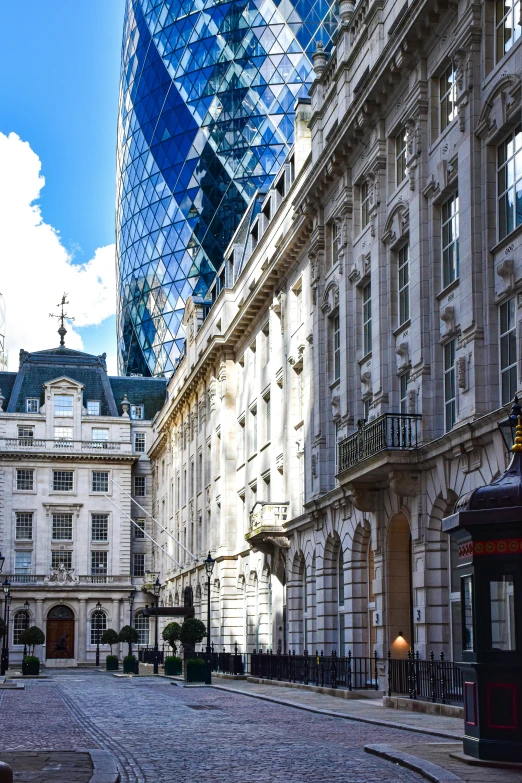 street in a european city with many buildings and an odd looking glass building