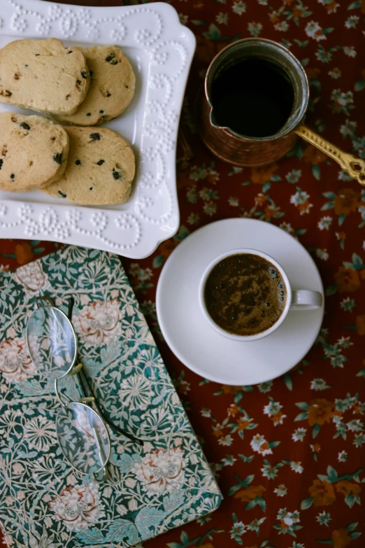 a table topped with plates of cookies and tea