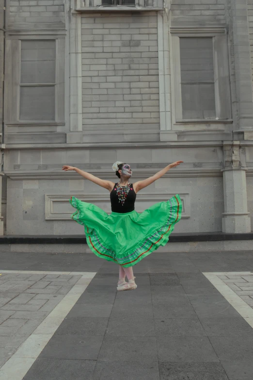 a girl in a green skirt standing on the corner