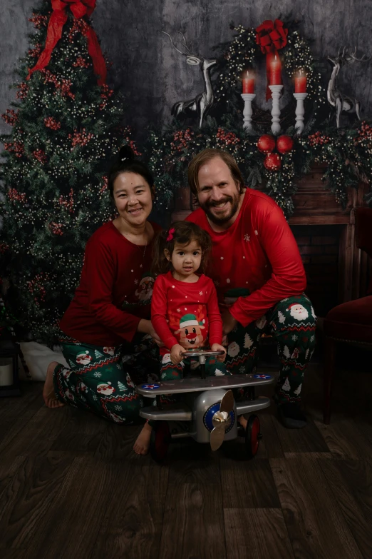 a family posing in front of a christmas tree