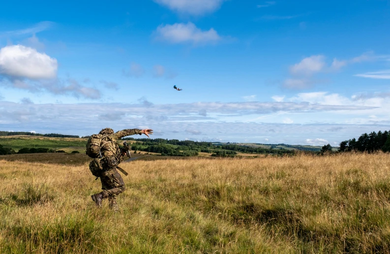 a man flying a kite in a green field