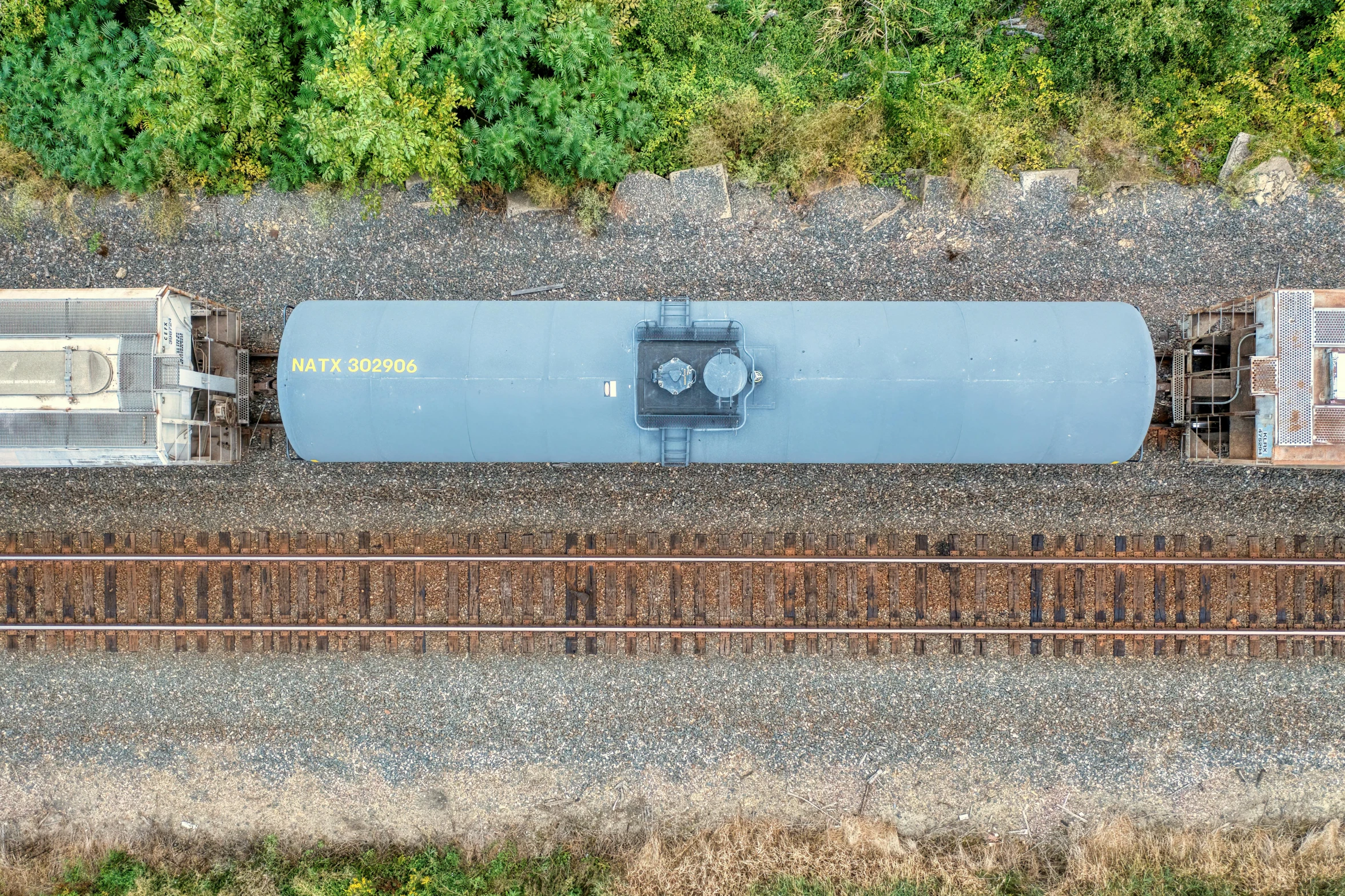 a long train is going along the tracks in the daytime