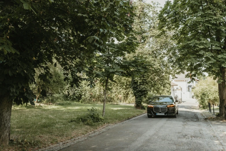 the car is parked on the side of a wooded road