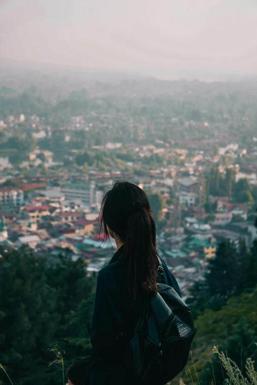 a woman looking out over a city on a hill