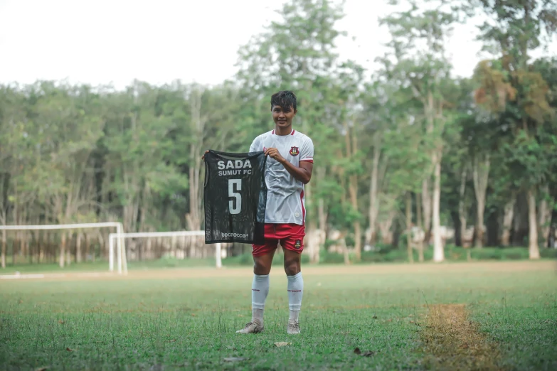 a soccer player standing in the grass with his uniform