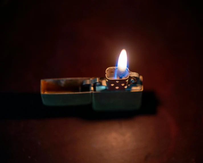 a cigarette lighter is glowing brightly on the dark ground