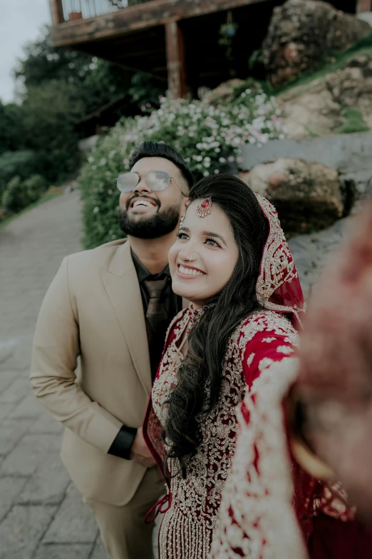 an indian couple holding each other with greenery around them