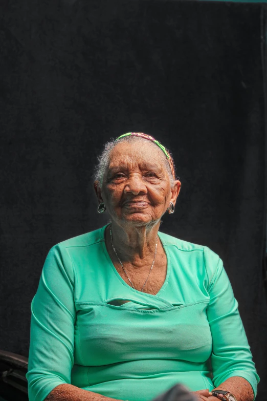 a woman smiling in front of a black wall