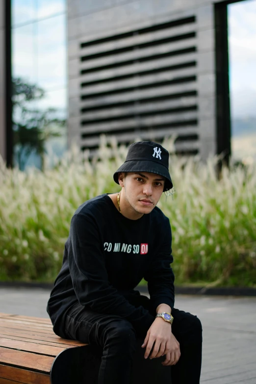 a young man sitting on top of a wooden bench