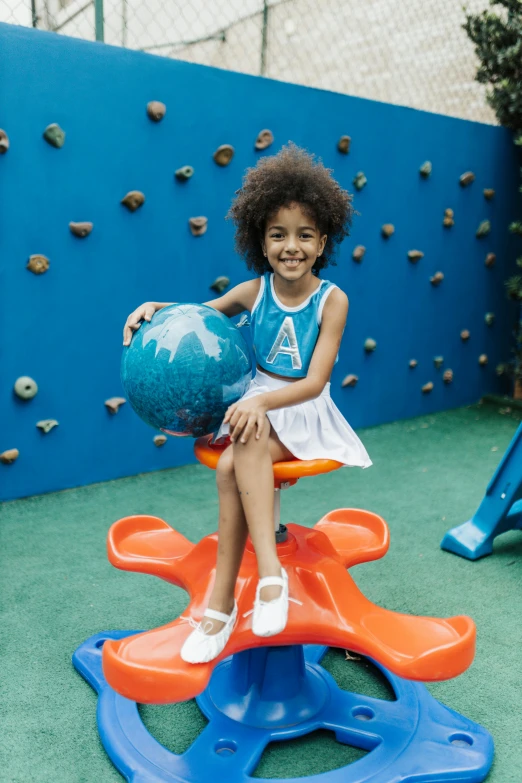 a little girl is sitting on an inflatable bench