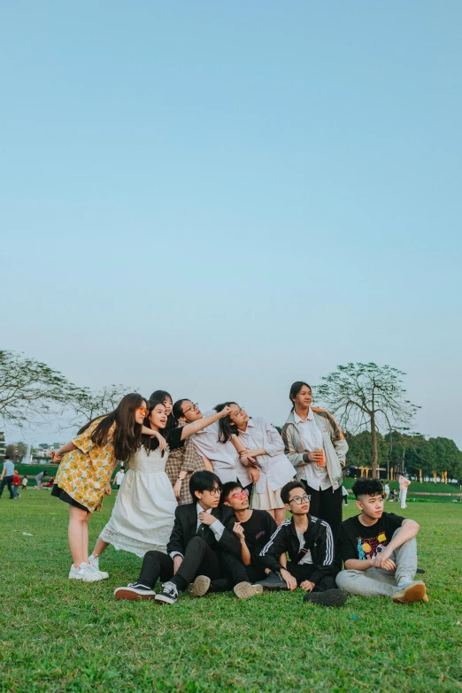 a group of people taking a picture together on the grass