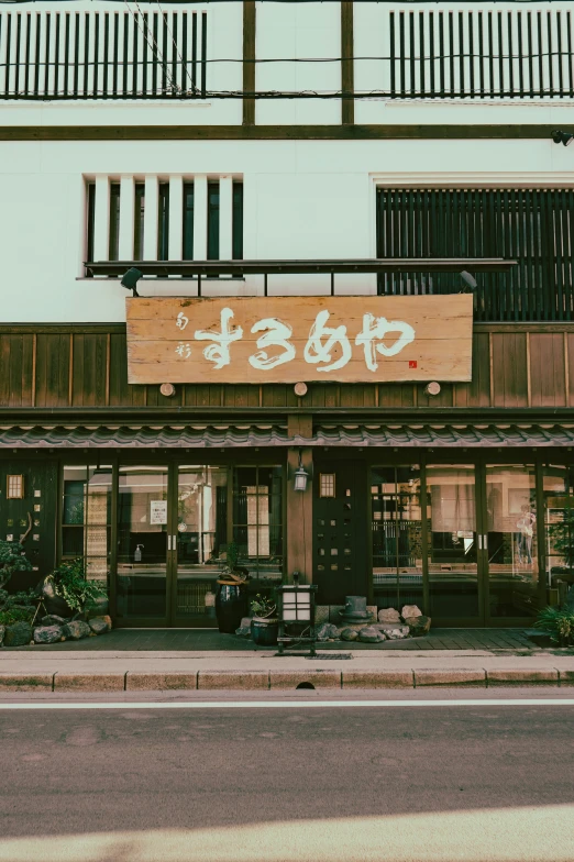 an old shop is decorated with japanese characters on a street corner