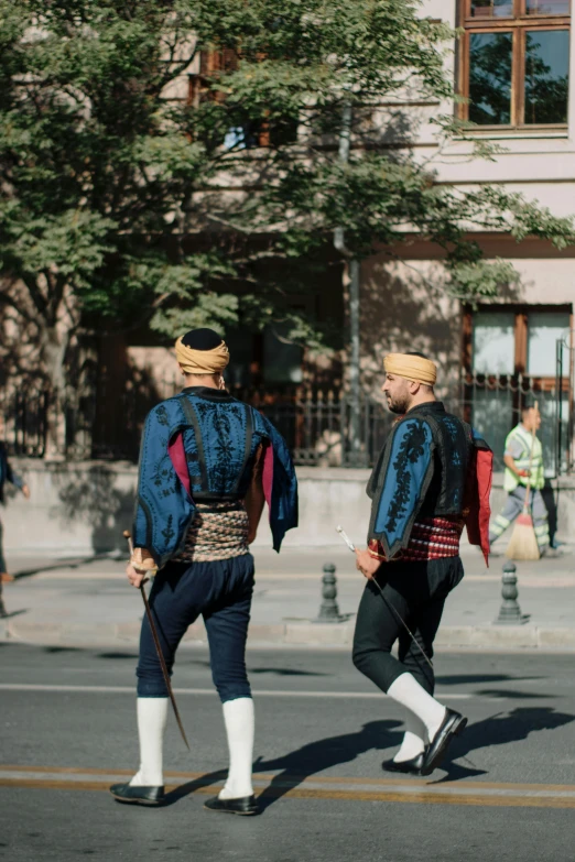 two people walking on the street with flags