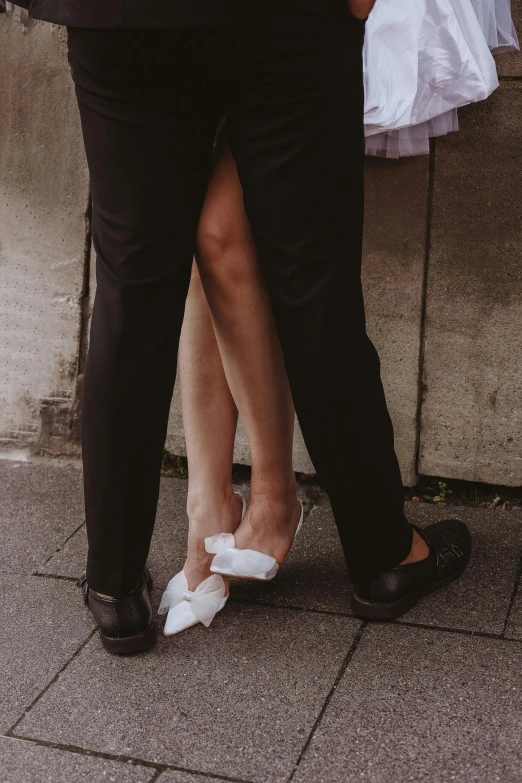 two people with shoes on standing next to each other