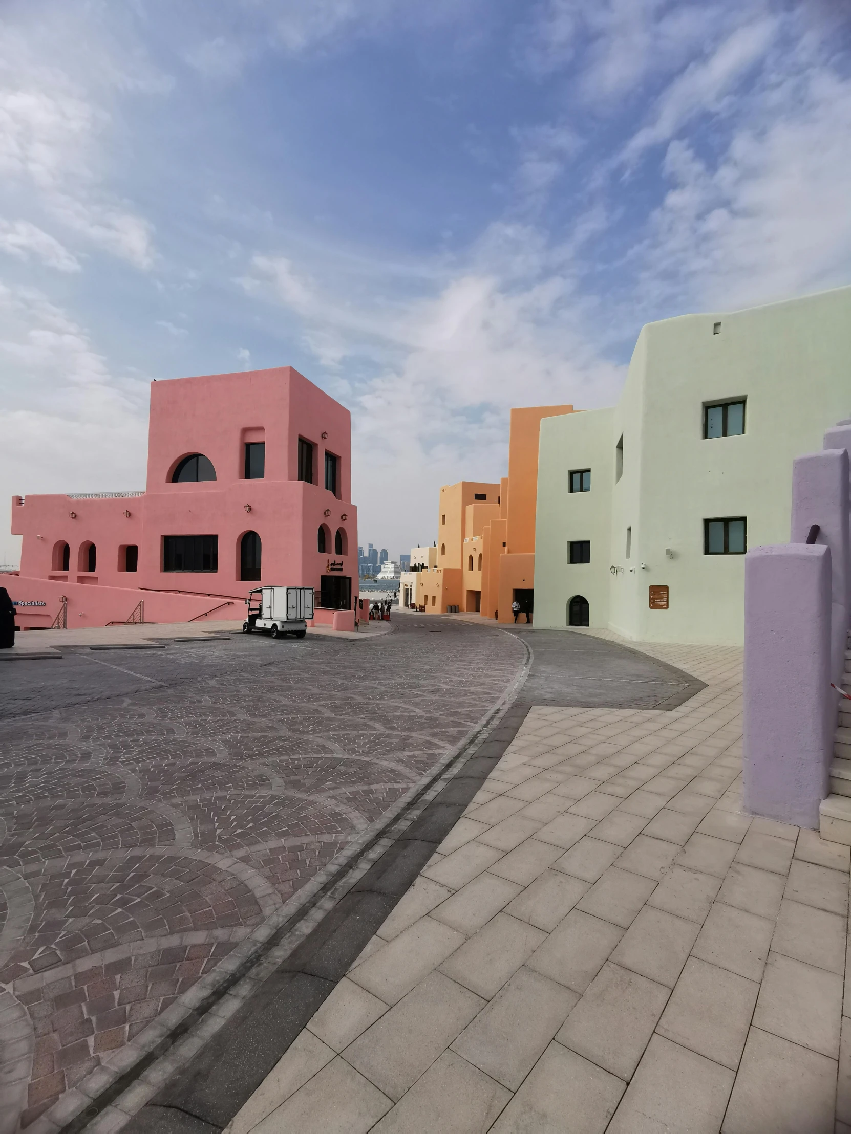 an empty parking lot surrounded by multicolored buildings