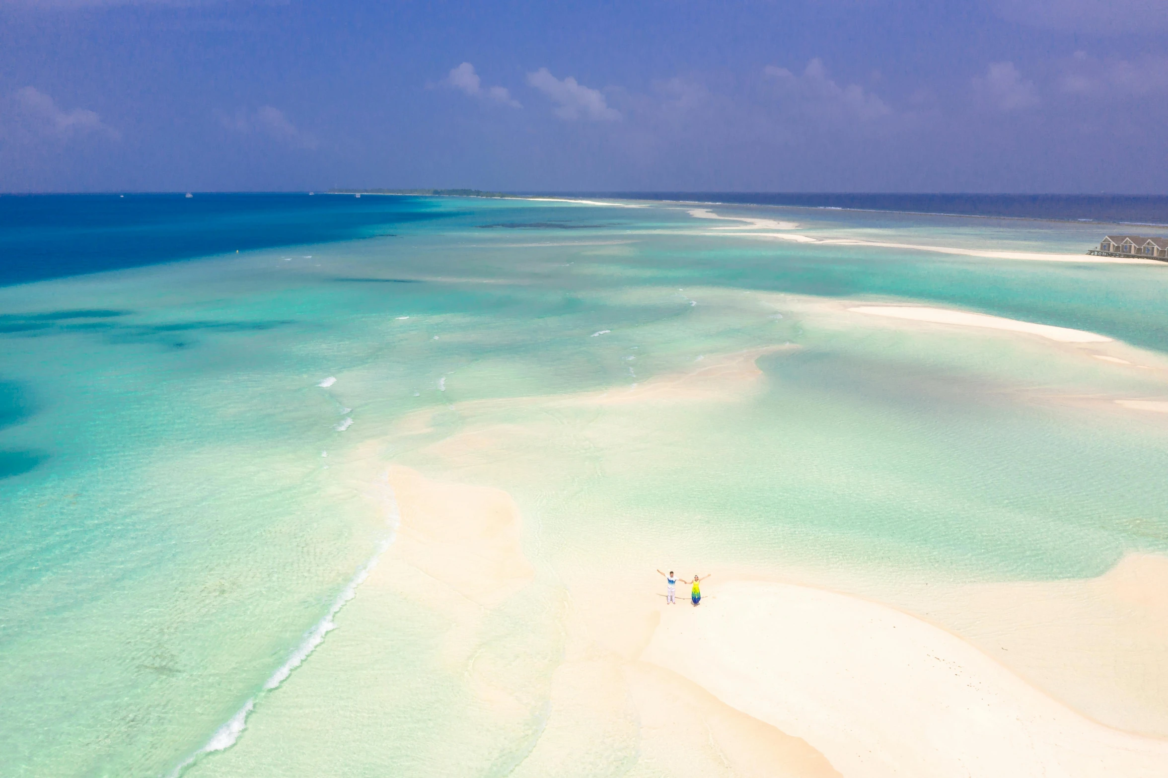 some people are walking on the white sand of a beach