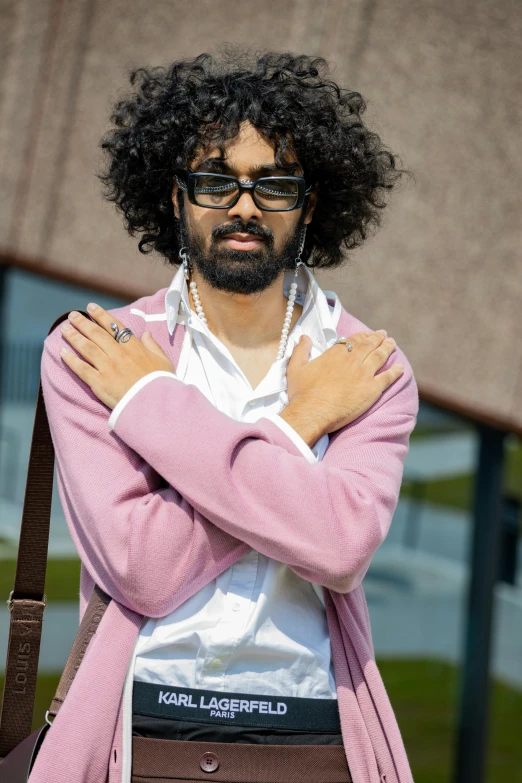 a man with an afro in sunglasses holding his arms over his chest