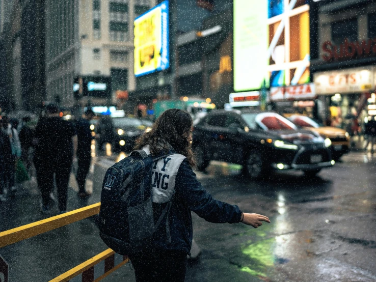 a woman standing on a sidewalk in the rain