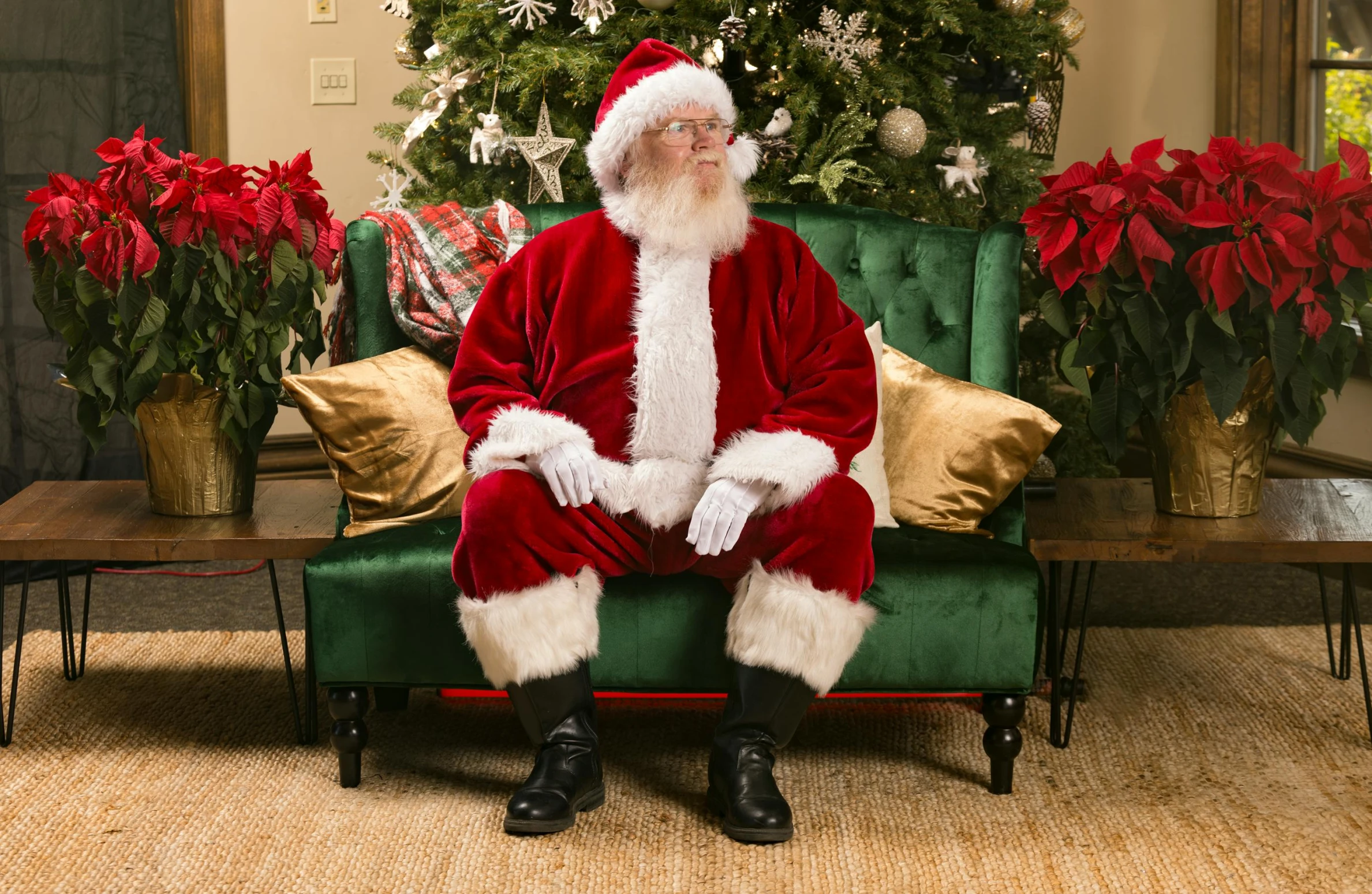 a santa clause sitting on a couch in front of a christmas tree