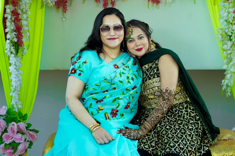 a bride and her mother pose for a pograph