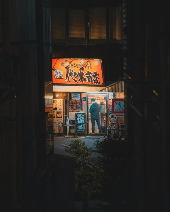 store front lit at night showing asian art