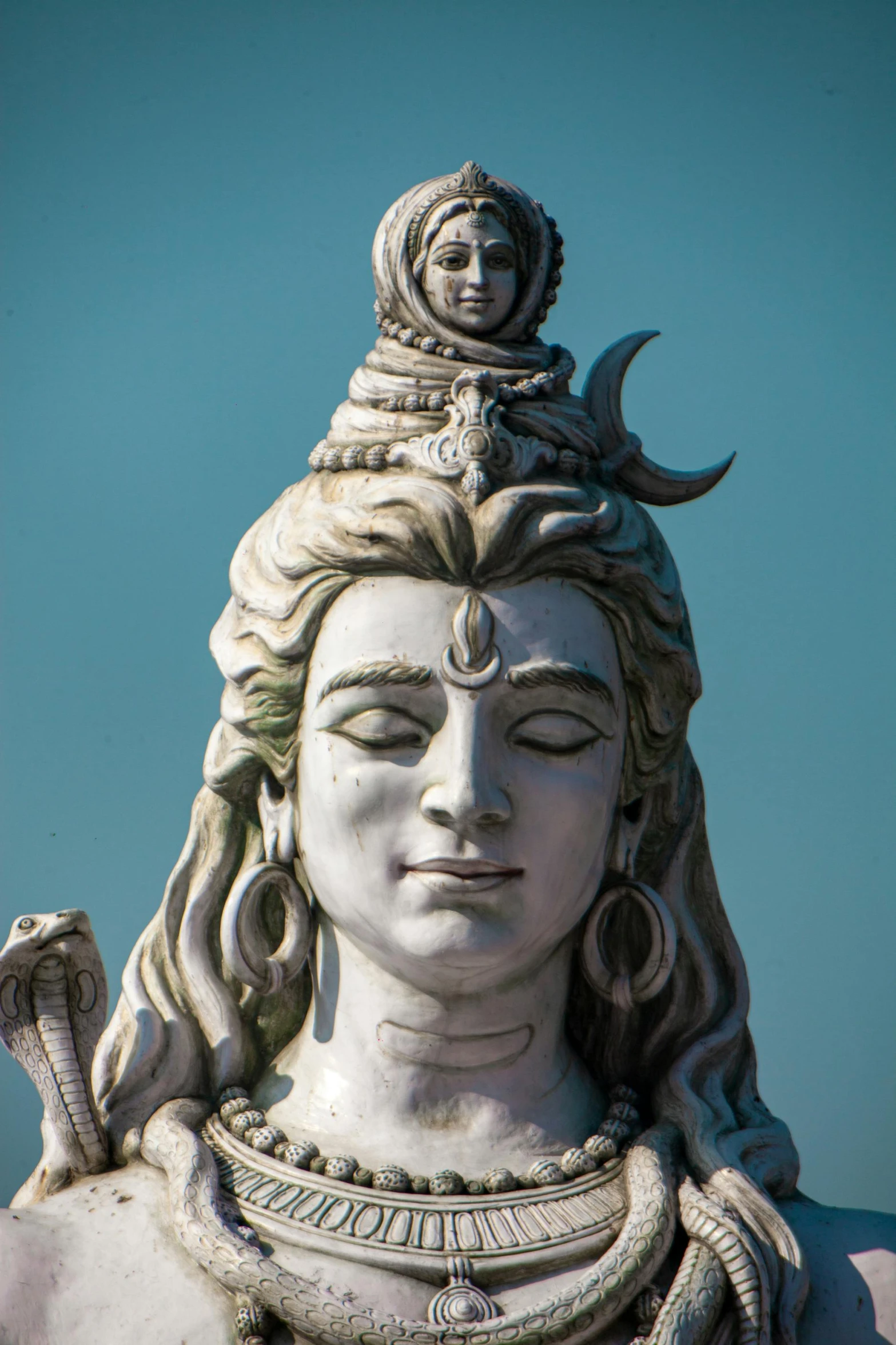 a statue with a long neck wearing an ornate necklace