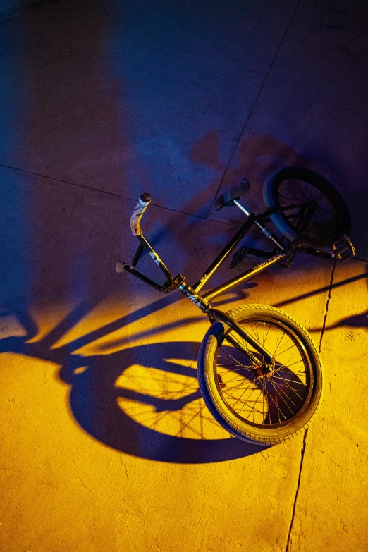 the shadow of a bicycle is cast on a sidewalk