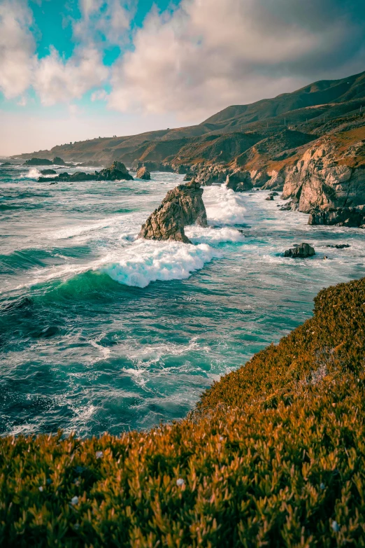 an ocean with lots of waves near a rocky cliff