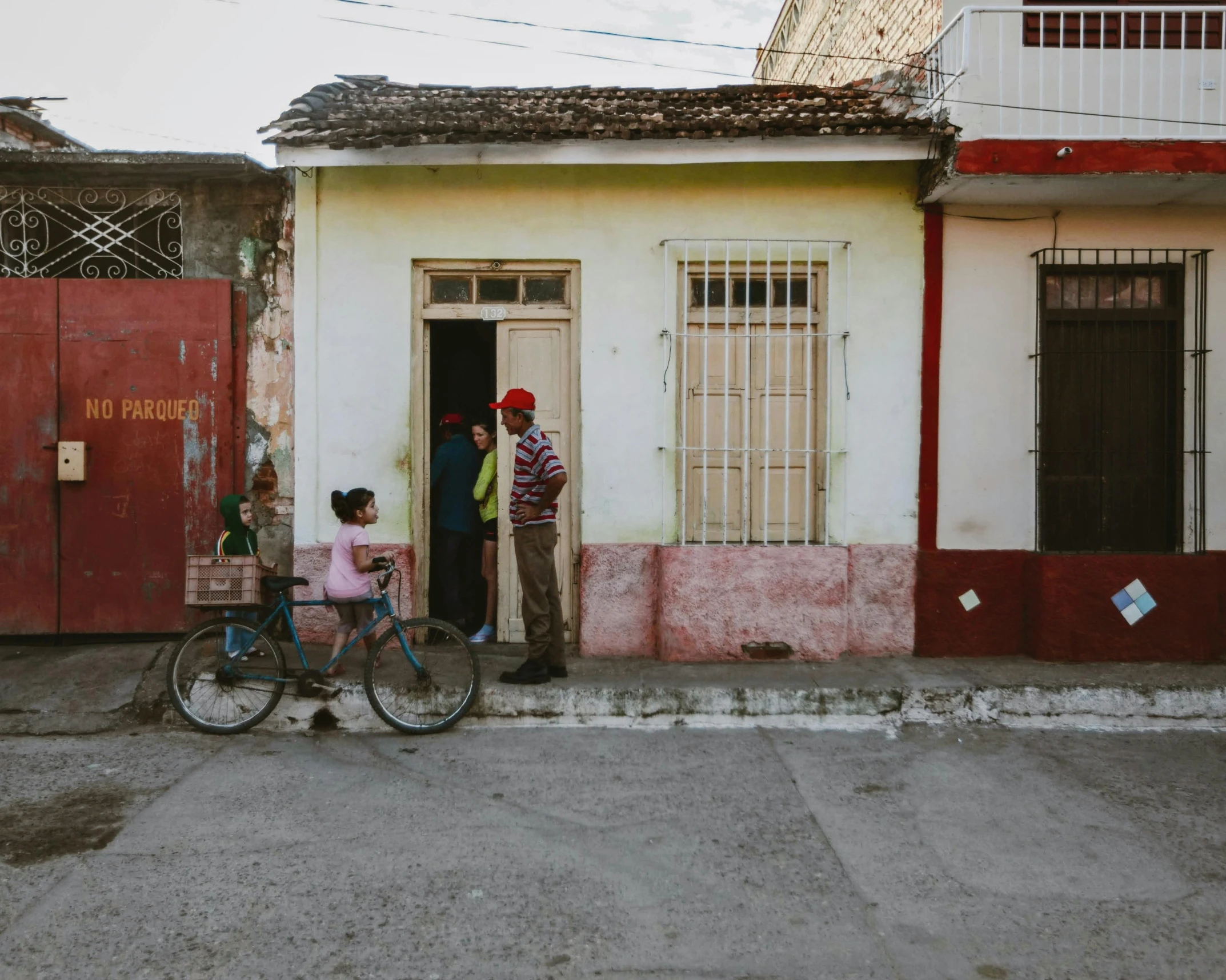 two people standing outside of a door of a house