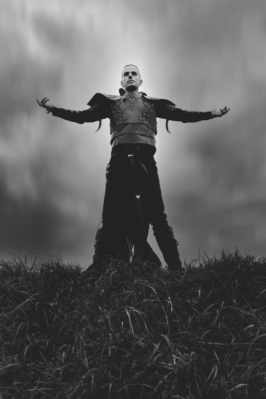 a scarecrow standing in a field with his arms spread wide