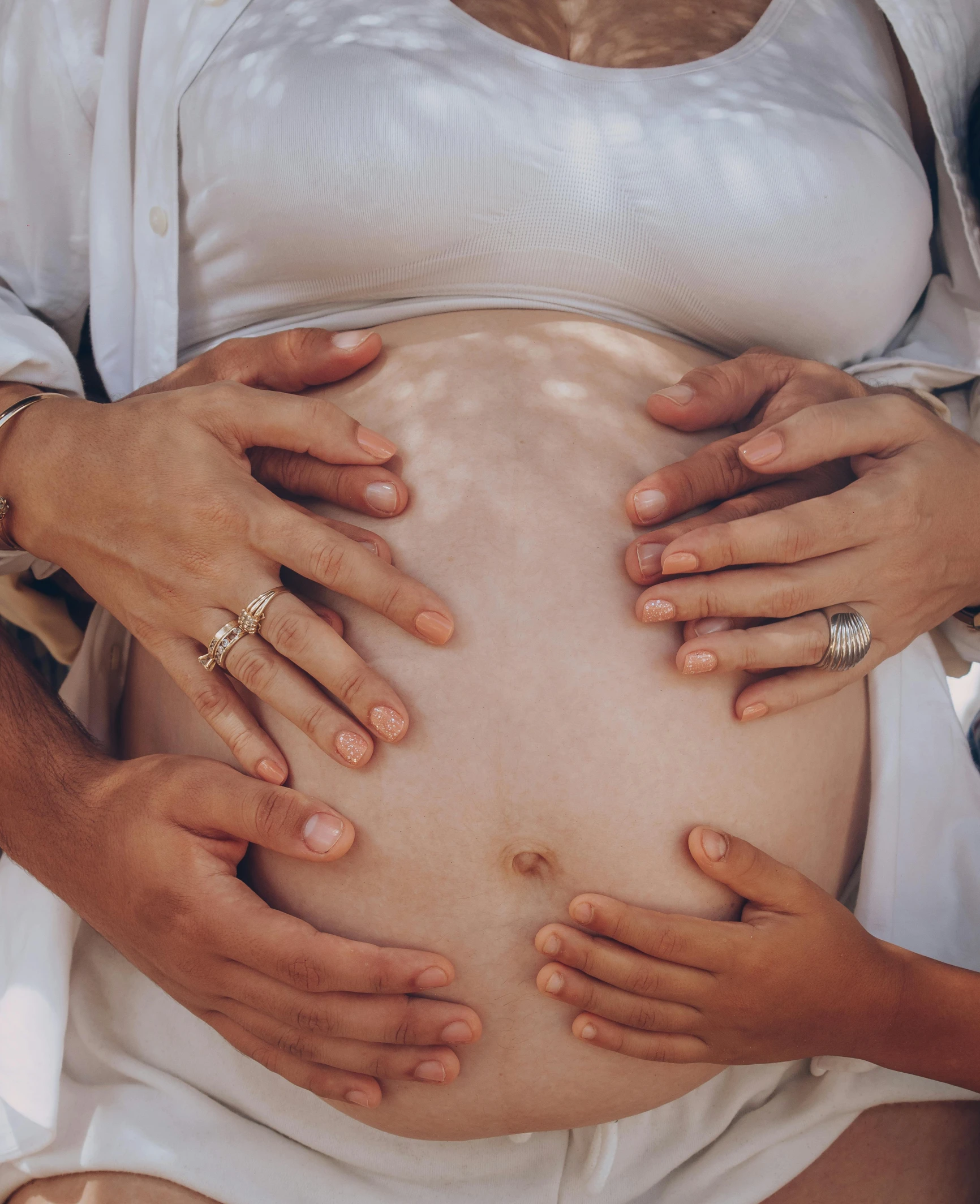 a pregnant woman holding her bump outside in front of her stomach