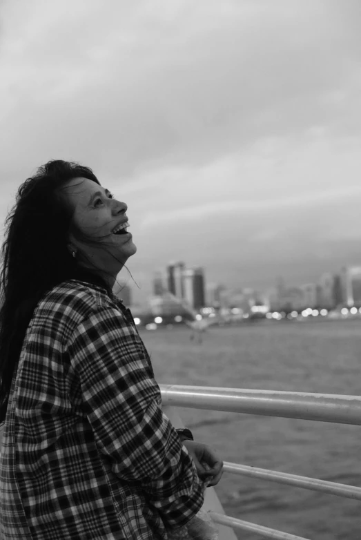 black and white po of a woman with long hair looking up at the sky