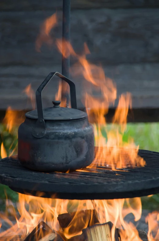 there is a kettle on a fire pit