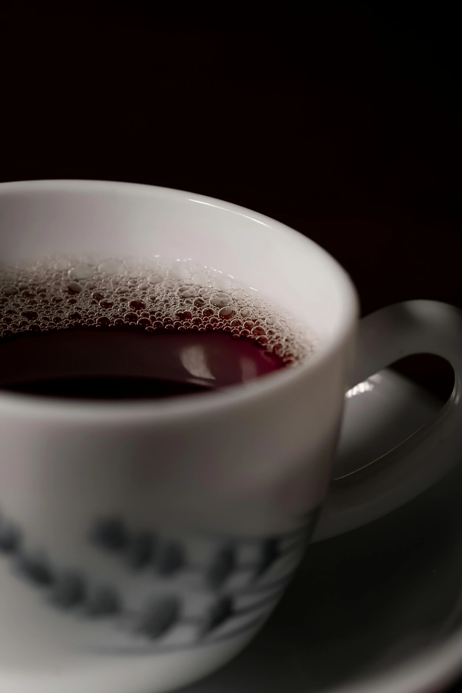 a white cup full of liquid on a white saucer