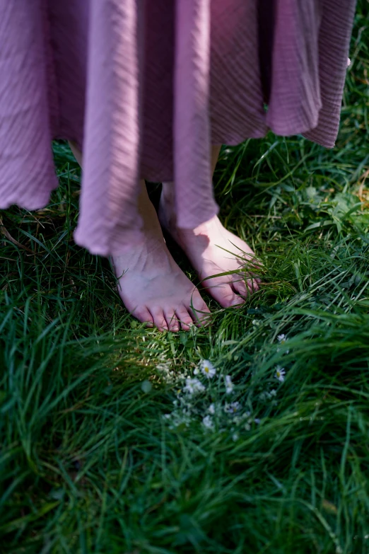 a woman's bare feet with the grass on a lawn