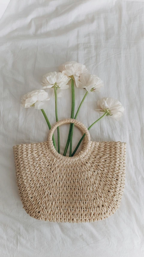 small white flowers sit atop an object made out of straw