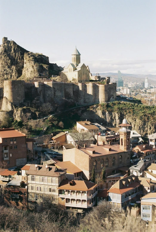 a view of buildings along a cliff above a city